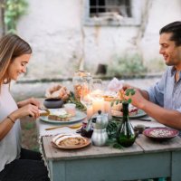 couple having a romantic candelight meal next to a cottage - garden decoration stockfoto's en -beelden