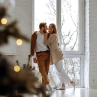 couple in love hugging near big window at home with christmas interior - fashion stock pictures, royalty-free photos & images