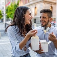 couple in the city eating fast food - junk food stock pictures, royalty-free photos & images