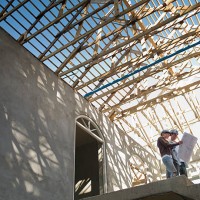 couple looking at blueprints in house under construction - home decoration stockfoto's en -beelden