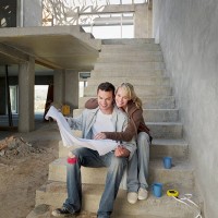 couple looking at blueprints on staircase of house under construction - home decoration stock pictures, royalty-free photos & images