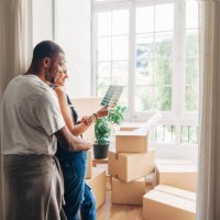 couple looking at color swatch while leaning by wall at new home - home decoration stock pictures, royalty-free photos & images