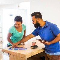 couple looking at paint samples and a tablet computer - home decoration stock pictures, royalty-free photos & images