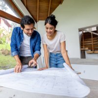 couple looking at the blueprints while renovating their house - home decoration stock pictures, royalty-free photos & images