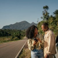 couple next to car using smartphone - travel stock pictures, royalty-free photos & images