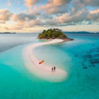 couple on idyllic tropical sandbar at sunset - travel stock pictures, royalty-free photos & images
