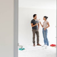 couple painting a wall together while renovating their house - home decoration stock pictures, royalty-free photos & images