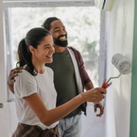 couple painting together in a bright and happy space - home decoration stock pictures, royalty-free photos & images