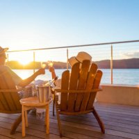 couple relaxing and drinking wine and toasting on deck chairs - travel stock pictures, royalty-free photos & images