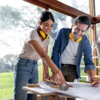 couple remodeling their house and looking at the blueprints - home decoration stock-fotos und bilder