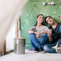 couple renovating new house, sitting on ground planning bathroom - home decoration stock pictures, royalty-free photos & images