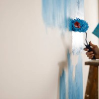 couple repainting the white wall into blue color - home decoration stock pictures, royalty-free photos & images