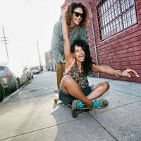 couple riding skateboard on city street - fashion stock pictures, royalty-free photos & images