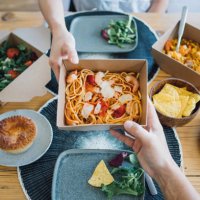 couple sharing takeaway meal at dining table - junk food stock pictures, royalty-free photos & images