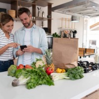 couple shopping for groceries online using a mobile application - food stock pictures, royalty-free photos & images