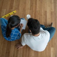 couple sitting at an empty room talking about interior design - home decoration stock pictures, royalty-free photos & images