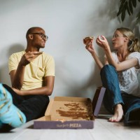 couple sitting on floor and having pizza - junk food stock pictures, royalty-free photos & images