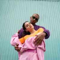 couple standing together in front of blue shutter door - fashion stock pictures, royalty-free photos & images