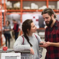 couple using smart phone in hardware store - home decoration stock pictures, royalty-free photos & images