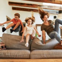 course pour la meilleure place sur le canapé. mère et enfants sautant. - home decoration photos et images de collection