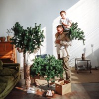 cozy christmas: parents and sons assemble the tree in a minimalist eco-friendly interior together - home decoration stock pictures, royalty-free photos & images