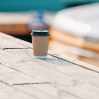 craft paper disposable coffee cup at the wooden pier and riverside background - junk food stock pictures, royalty-free photos & images