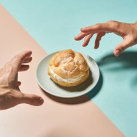 cream puff and hands on a colorful background. - food stock pictures, royalty-free photos & images
