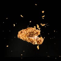 crispy chicken meat flying in mid air captured with high speed sync.