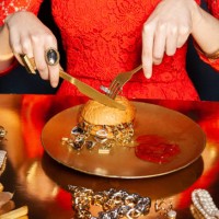 crop woman eating burger with jewelry on dark background - food stock-fotos und bilder