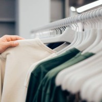 cropped hand of man holding shirt in shop - fashion stock pictures, royalty-free photos & images
