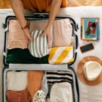 cropped photo of an unrecognizable woman putting a cosmetic bag in her suitcase - travel stock pictures, royalty-free photos & images