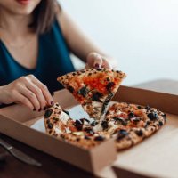 cropped shot of young woman eating pizza from pizza box at. food delivery. takeaway food. - junk food stock pictures, royalty-free photos & images