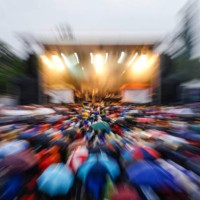 crowded music festival with audience carrying umbrellas - concert stock pictures, royalty-free photos & images