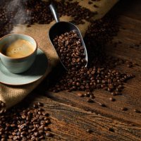 cup of coffee with smoke and coffee beans on old wooden background - coffee stock pictures, royalty-free photos & images