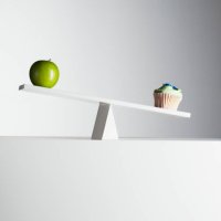 cupcake tipping seesaw with green apple on opposite end - junk food stock pictures, royalty-free photos & images