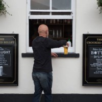 Customer is served a pint of beer via a window at the Crooked Billet pub on July 04, 2020 in Leigh-on-Sea, United Kingdom. The UK Government...