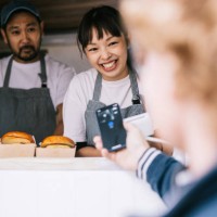 customer making a mobile payment at food truck - junk food stock pictures, royalty-free photos & images