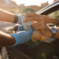customer taking his coffee and food order from the service person at the drive through - junk food stock pictures, royalty-free photos & images