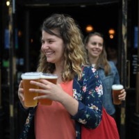 Customers leave with pints of beer for takeaway at The Ten Bells pub in east London on June 27, 2020. The pub serves drinks for takeaway to maintain...