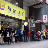 Customers queue outside a restaurant for takeout lunch orders in Hong Kong, China, on Thursday, Feb. 24, 2022. Existing curbs on restaurants, gyms...