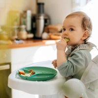 cute baby girl eating meal at high chair - food stock pictures, royalty-free photos & images
