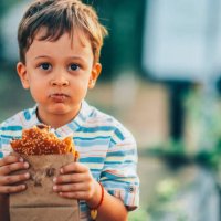 cute boy eating a burger outside - junk food stock pictures, royalty-free photos & images