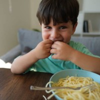 cute child eating spaghetti. - food stock pictures, royalty-free photos & images