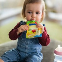 cute little girl eating fruit puree in pouch - food stock pictures, royalty-free photos & images