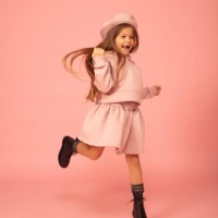 cute little girl jumping in a mini dress against a pink background. - fashion stock pictures, royalty-free photos & images