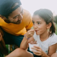 cute young girl enjoying ice cream with her father in park - food stock pictures, royalty-free photos & images