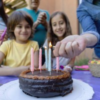 daddy lightining birthday candles while everyone waits to sing happy birthday to little boy - garden decoration stock pictures, royalty-free photos & images