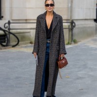 Darja Barannik wears grey coat, brown bag, denim jeans, black shirt outside Chanel during Womenswear Spring/Summer 2025 as part of Paris Fashion Week...