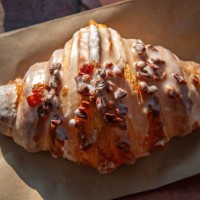 date and pecan iced croissant on a brown paper bag - junk food stock pictures, royalty-free photos & images