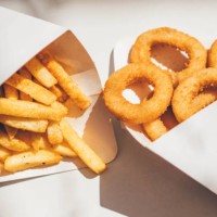 deep-fried onion rings and french fries. - junk food stock pictures, royalty-free photos & images